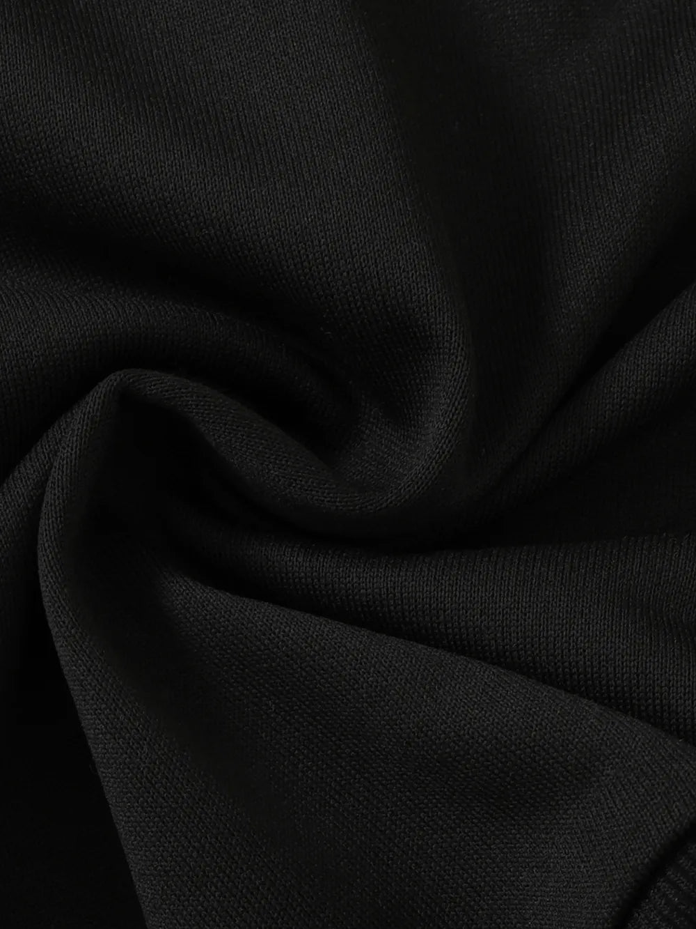Black fabric with a smooth texture, slightly wrinkled and folded, showcasing deep color.