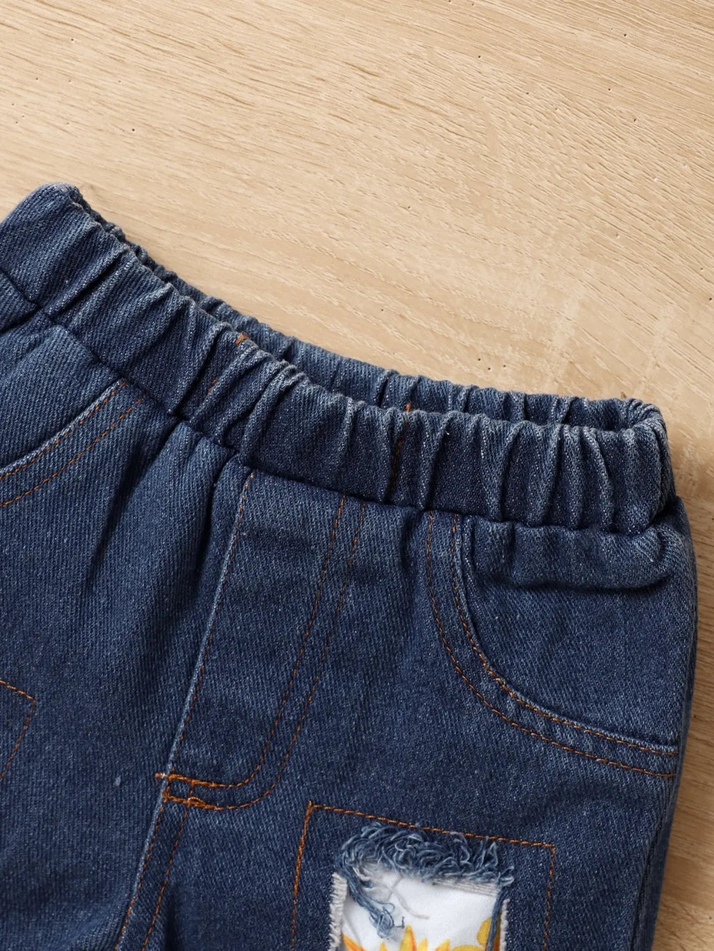 Denim shorts with elastic waistband and decorative patch on the front.