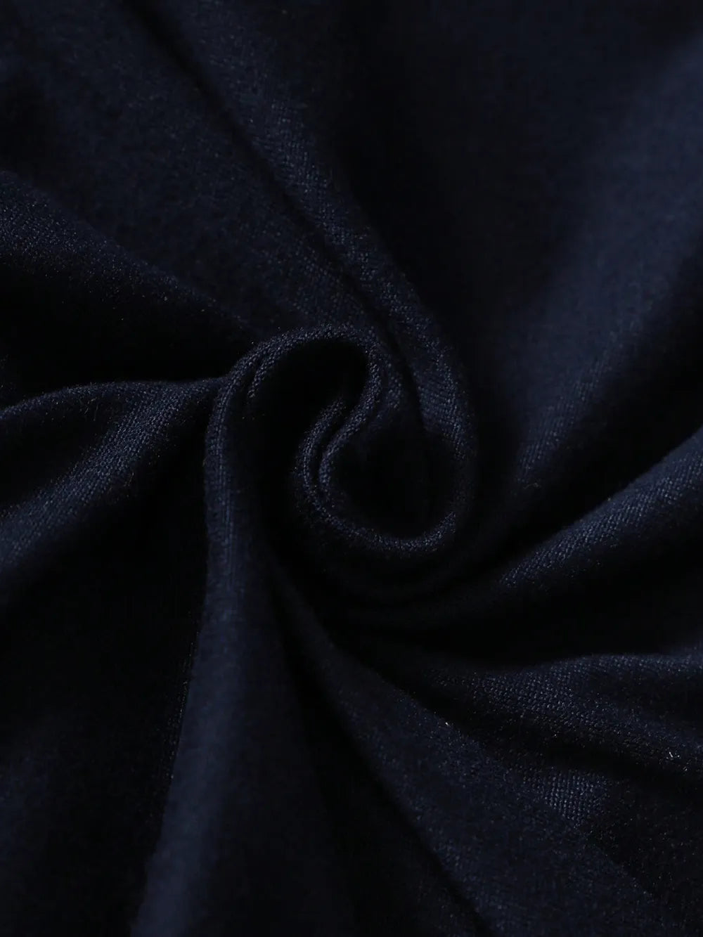 Navy blue fabric twisted into a spiral, showcasing its smooth texture and depth of color.