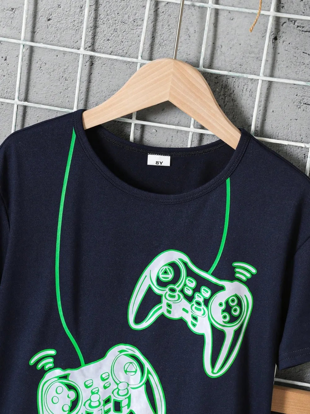 Navy t-shirt featuring glowing green illustrations of gaming controllers.