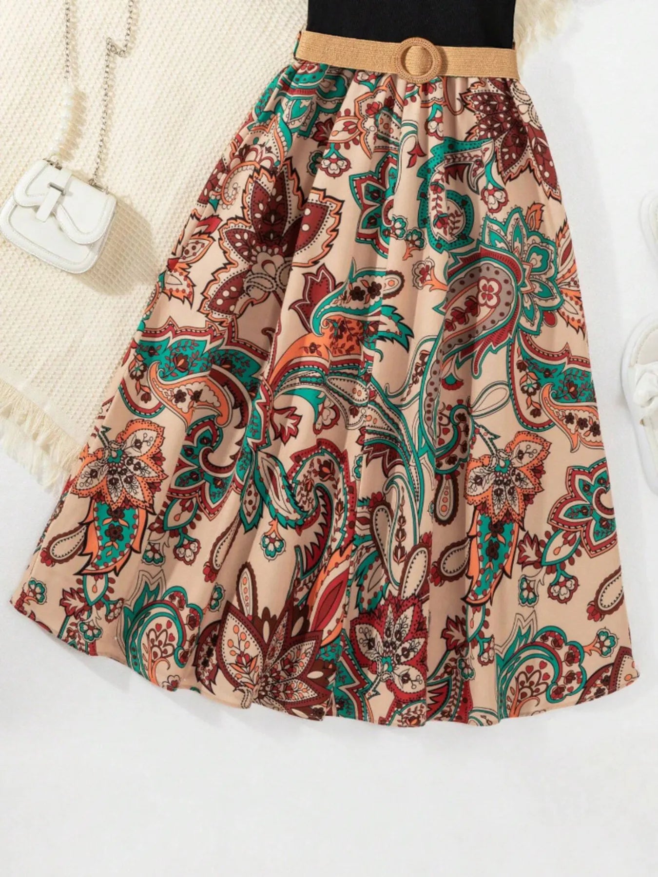 Floral-patterned skirt in warm tones, featuring a beige background and colorful paisley designs.
