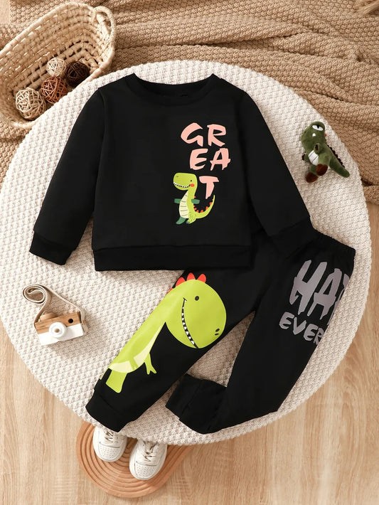 Black children's sweatshirt and pants featuring a dinosaur design, arranged on a round mat.
