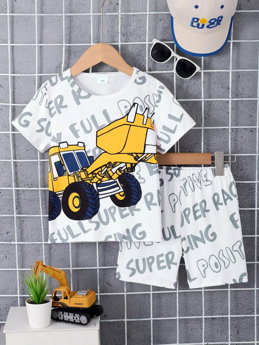 Children's outfit featuring a truck graphic tee and shorts, with sunglasses and a cap nearby.